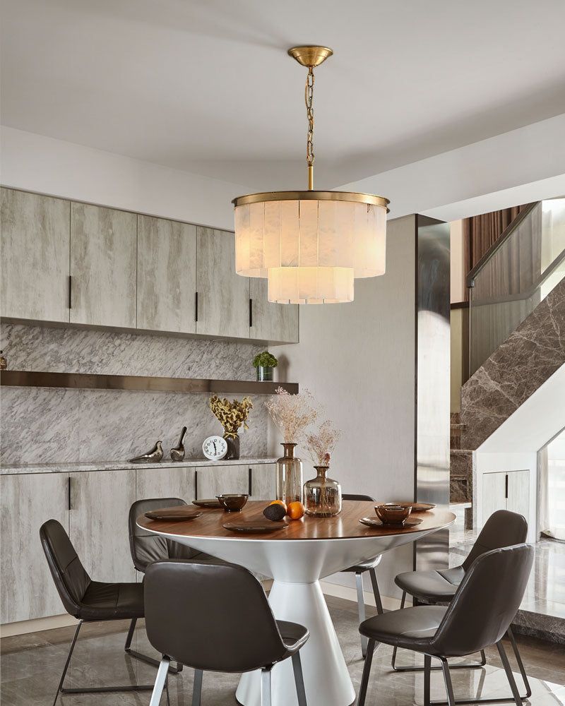 Brass and alabaster chandelier above round dining table in modern kitchen setting