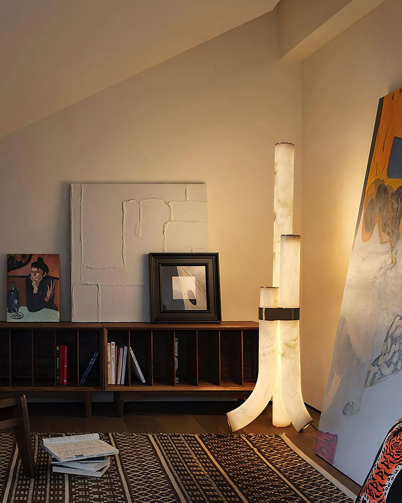 Chic alabaster floor lamp emitting warm light in a modern interior with art and furniture