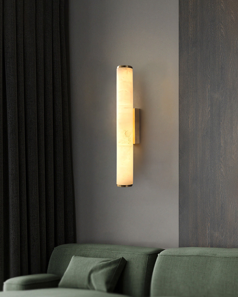 Cylindrical alabaster wall sconce lamp casting warm light in modern living space