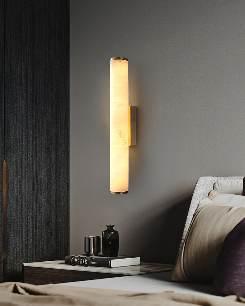 Cylindrical alabaster wall sconce lamp enhancing modern bedroom decor with warm glow