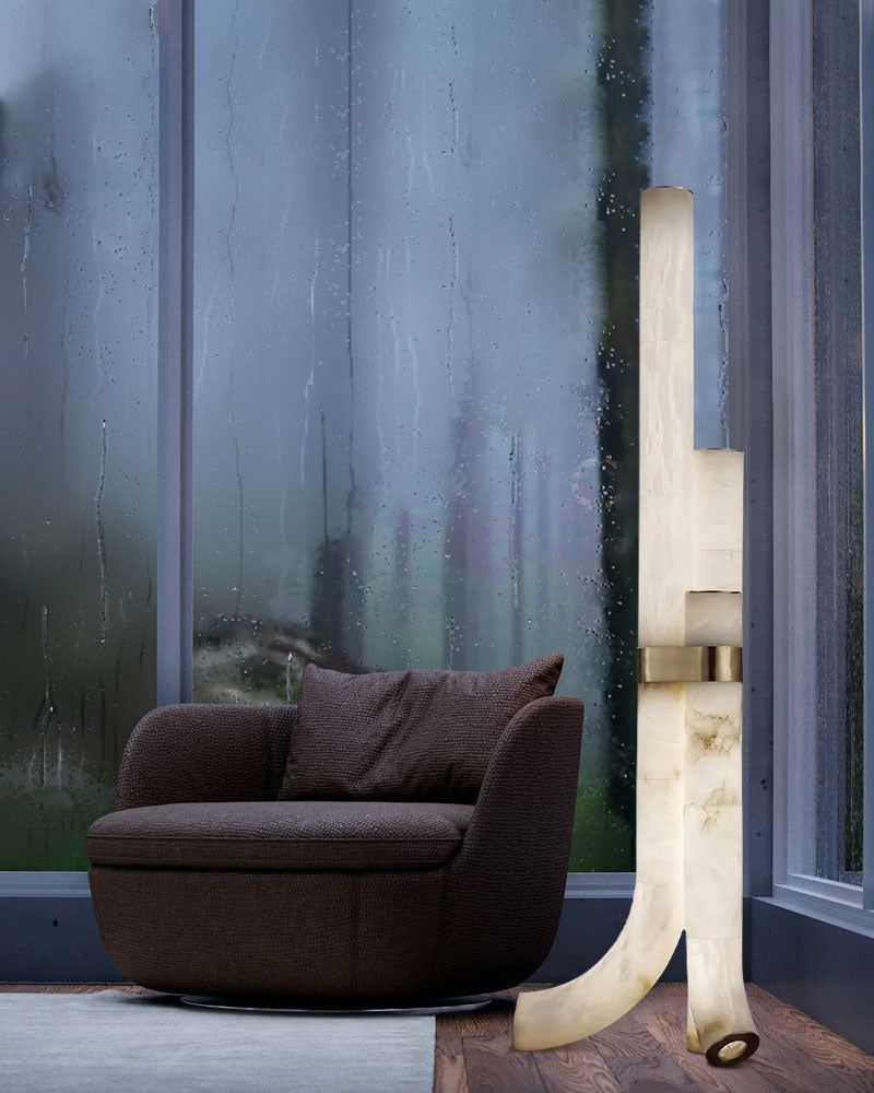 Elegant floor lamp with alabaster shades and sleek design beside a modern armchair