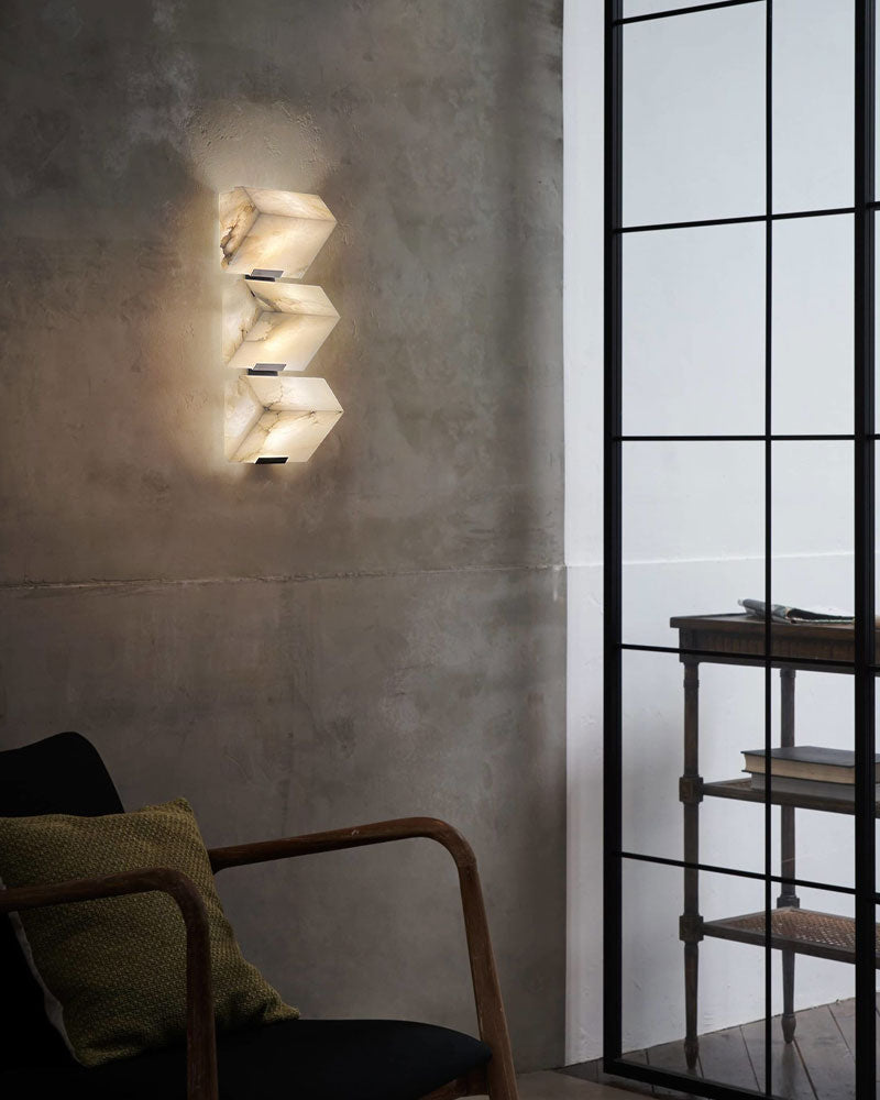 Geometric LED alabaster wall sconce illuminating a modern living space