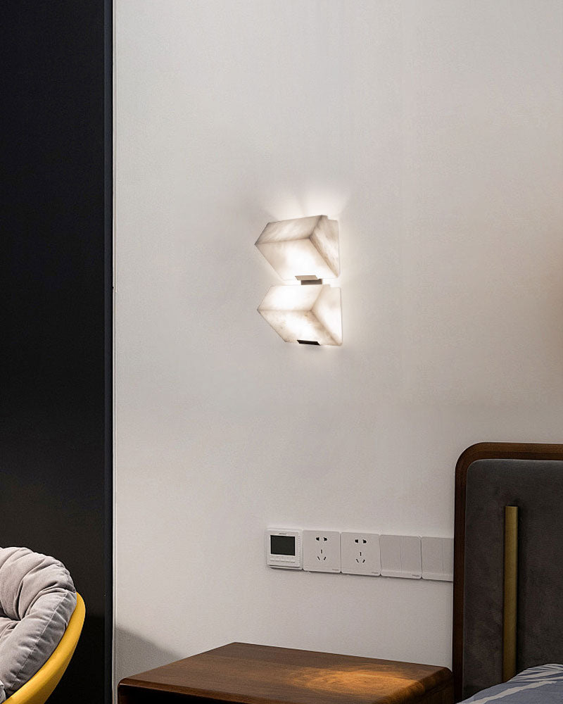 Geometric LED alabaster wall sconce illuminating stylish bedroom interior with sloping design