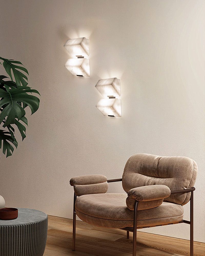 Geometric LED alabaster wall sconces illuminating a cozy modern living room