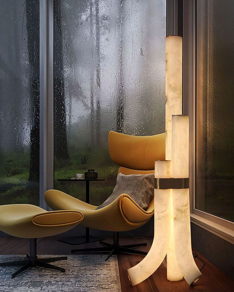 Geometric alabaster floor lamp next to a yellow armchair in a stylish interior