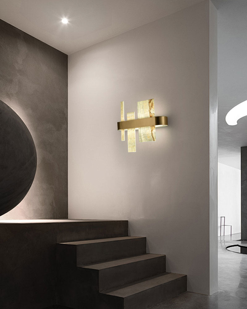 Luxury marble and metal wall sconce illuminating a modern staircase