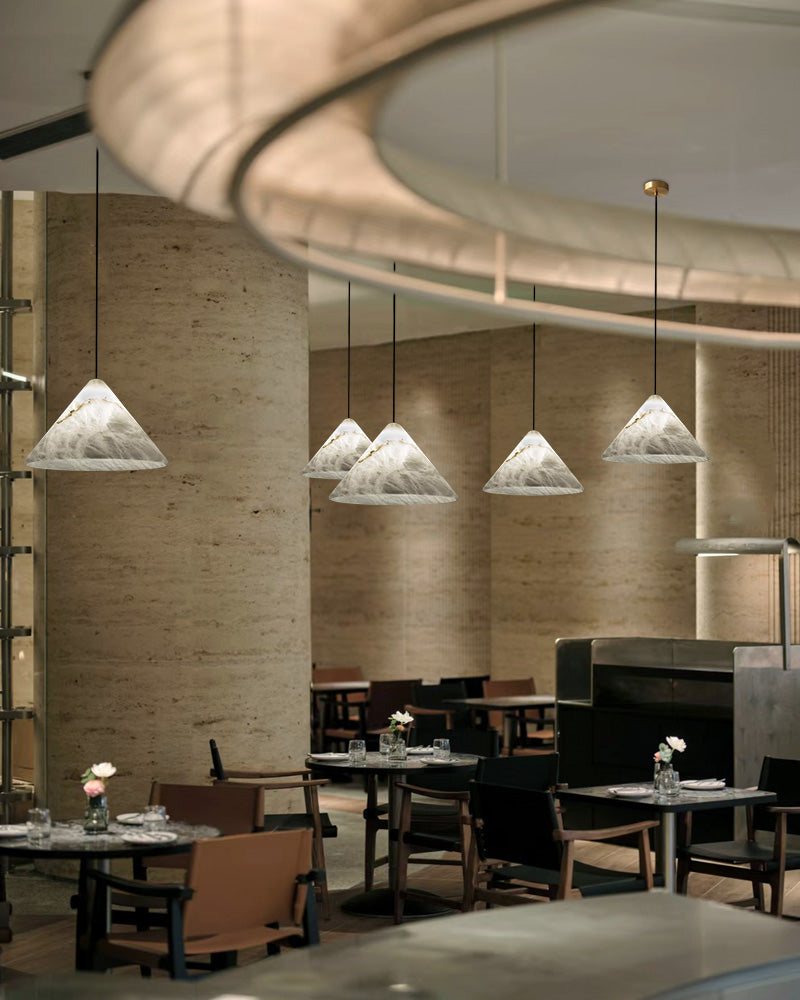 Multiple alabaster pendant lamps above tables in a chic restaurant dining area