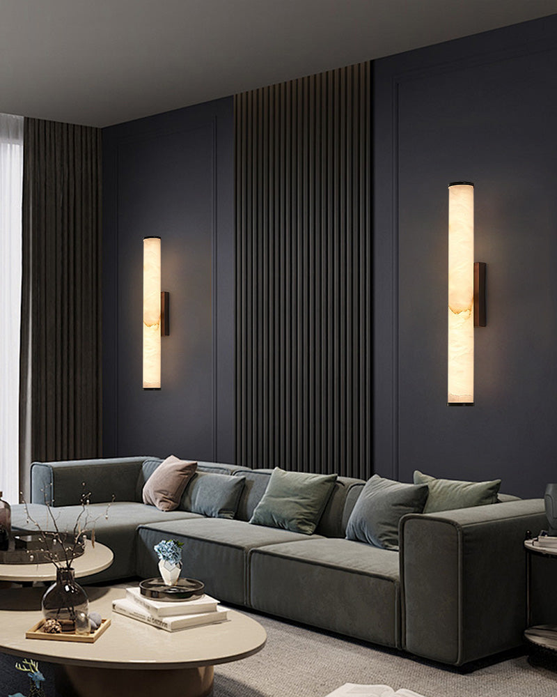 Modern living room with green sofa and cylindrical alabaster wall sconce lamps