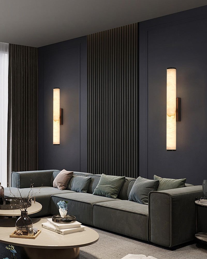 Modern living room with green sofa and cylindrical alabaster wall sconce lamps