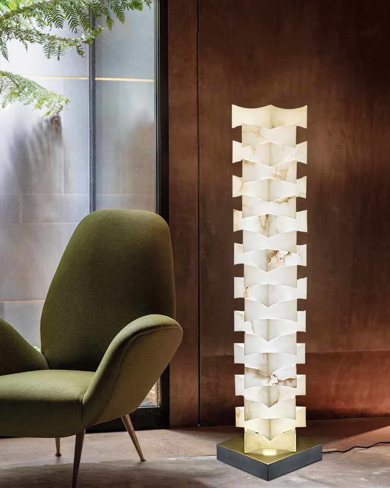 Modern LED stacked floor lamp with alabaster shade next to green armchair in stylish room