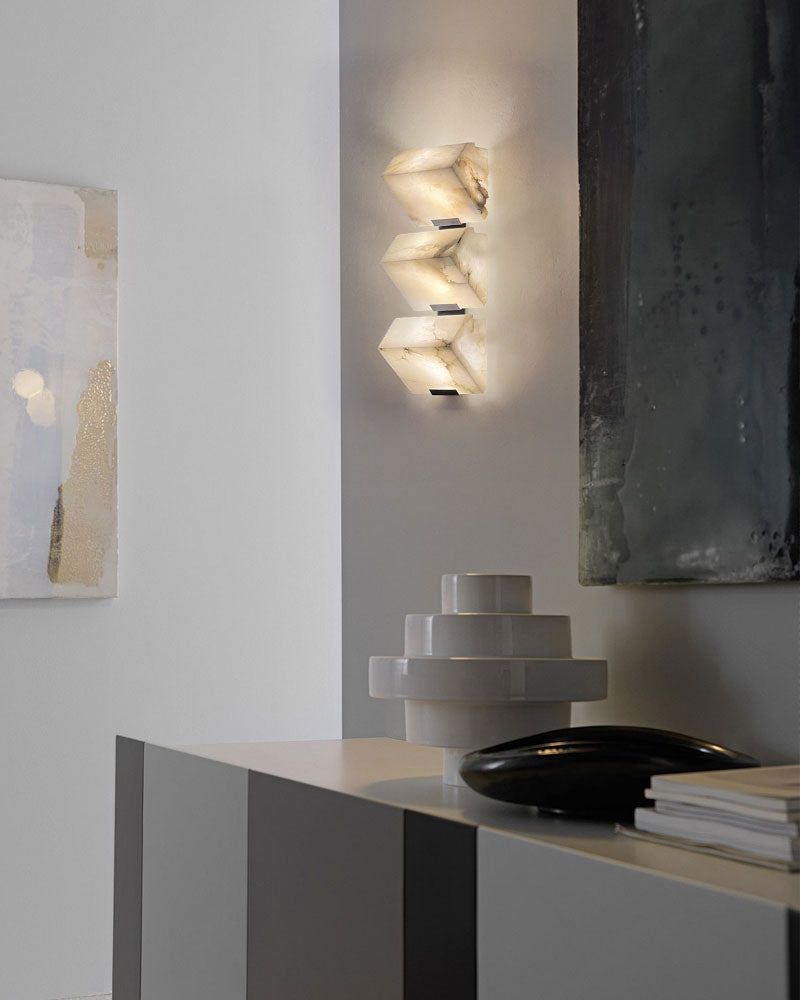 Modern LED wall sconce with sloping alabaster design illuminating a stylish interior