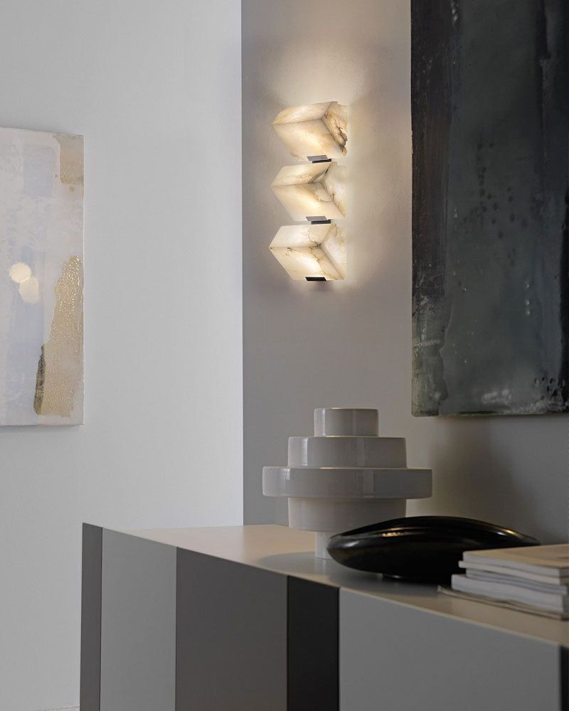 Modern LED wall sconce with sloping alabaster design illuminating a stylish interior