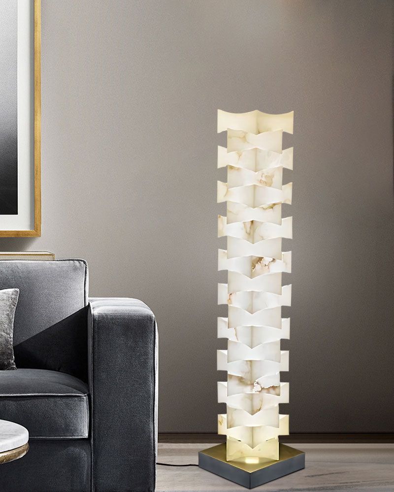 Modern stacked LED floor lamp with alabaster shade beside gray sofa in chic living room