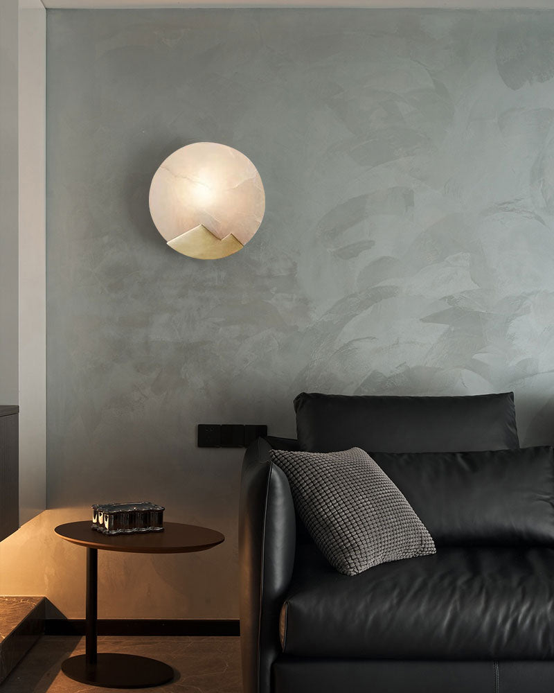 Nordic alabaster LED wall sconce with mountain design above black sofa in stylish interior