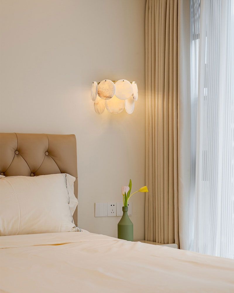 Spanish Alabaster Shell lamp in brass illuminating a modern bedroom with soft bedding