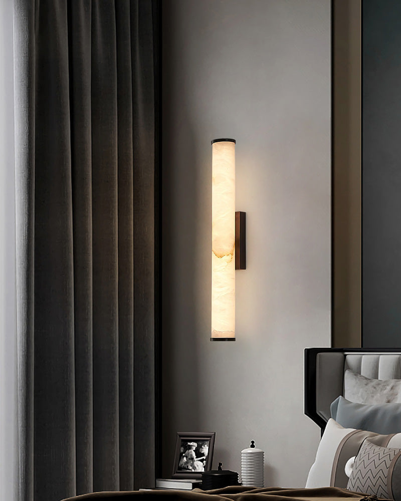Stylish cylindrical alabaster wall sconce lamp in modern bedroom setting