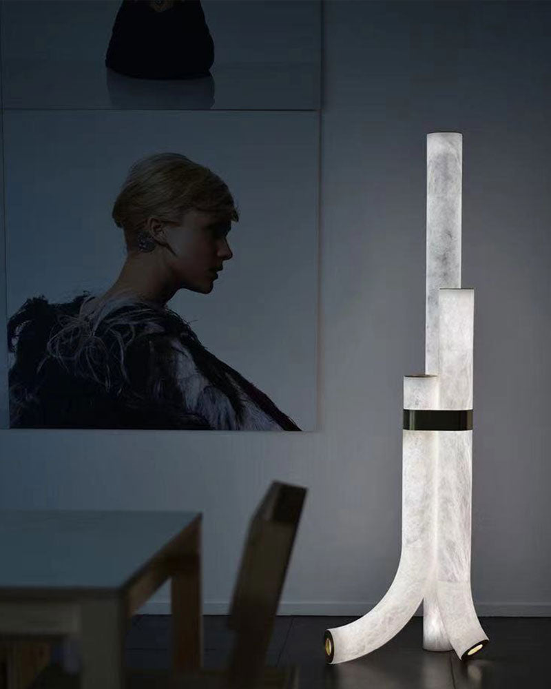 Tall geometric alabaster floor lamp with brass accents in stylish modern interior